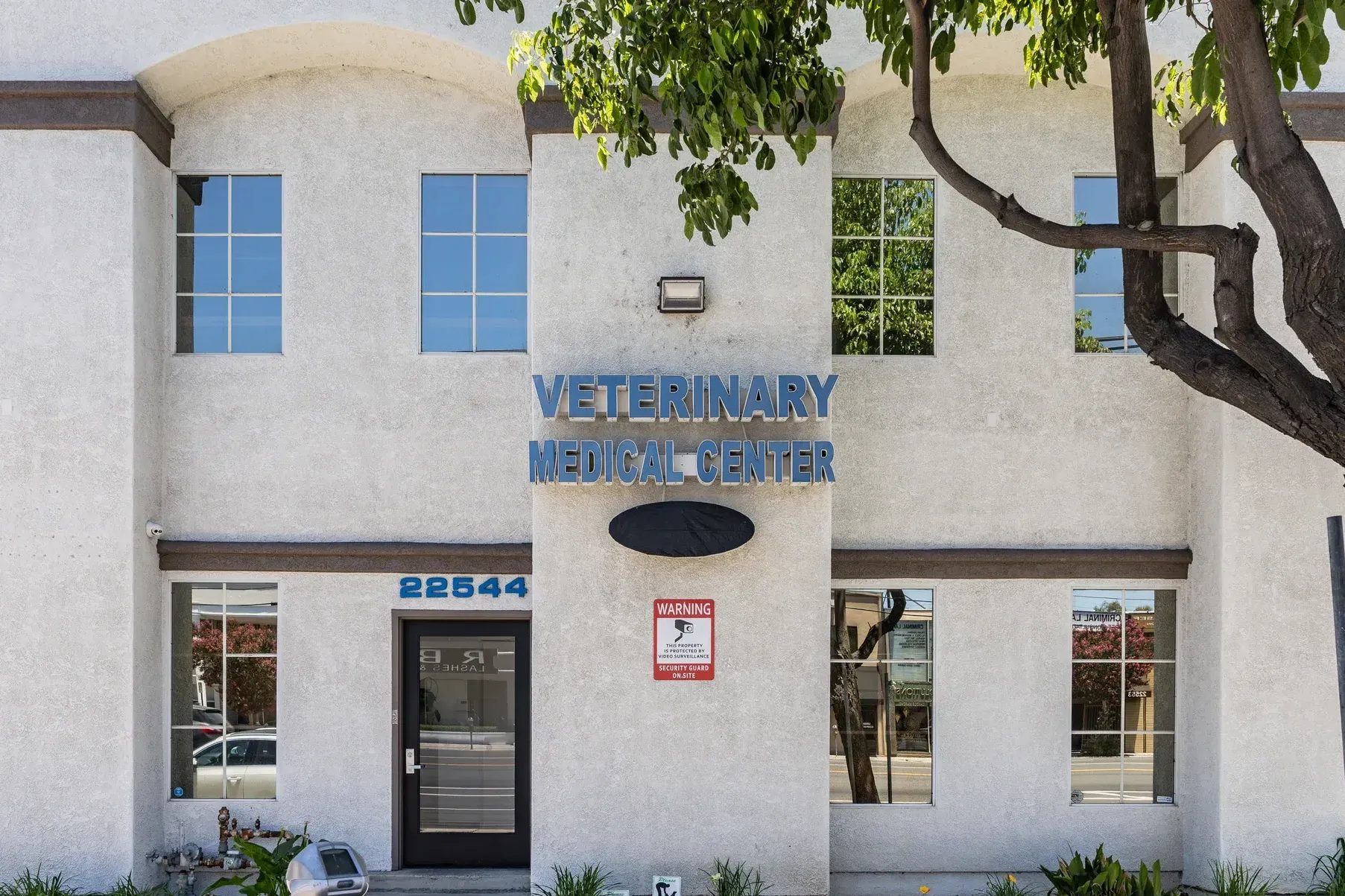 Exterior of Veterinary Medical Center of Woodland Hills building with blue signage and tree